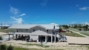 A two-story building with a balcony and a covered area, located near a road with vehicles. - Seascape St. George Island (Saint George Island)