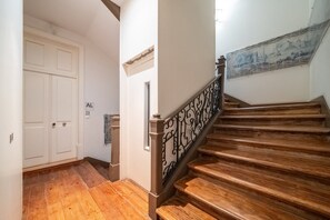 A wooden staircase with a black iron railing leading to a landing. - GuestReady - Elegant Central Home with Terrace (Lisbon)