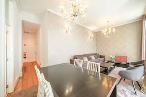 Ein modernes Wohnzimmer mit Esstisch, Sofas und Fernseher.