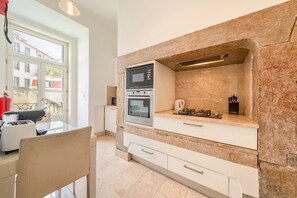 Eine Küche mit Steinrückwand, einem Gasherd, einem Backofen und einer Mikrowelle.