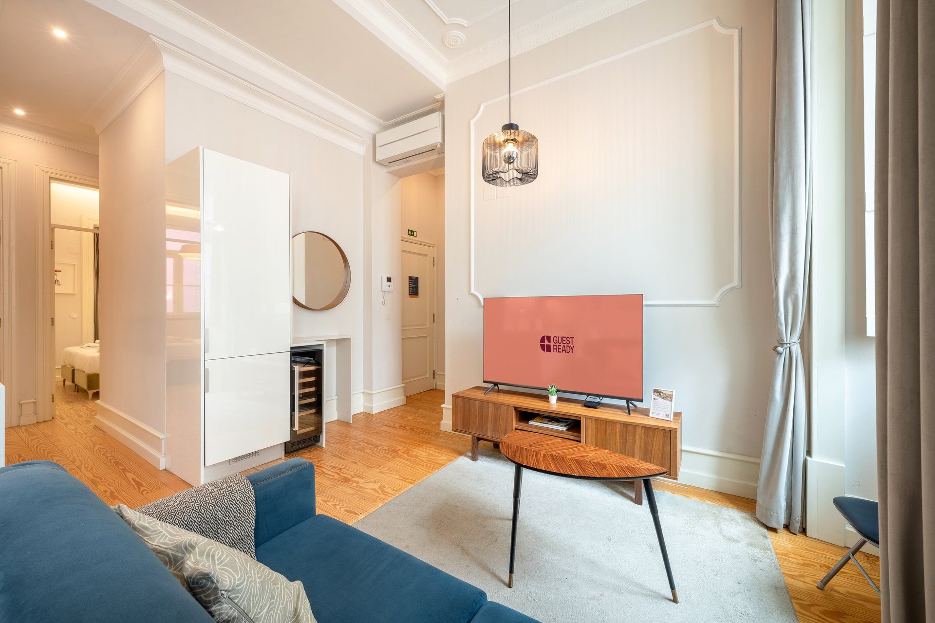 Una sala de estar moderna con una televisión de pantalla plana, un sofá, una mesa de centro y una chimenea.
