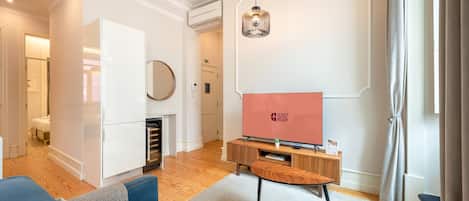 Una sala de estar moderna con una televisión de pantalla plana, un sofá, una mesa de centro y una chimenea.