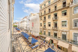 Una strada con posti a sedere all'aperto e palazzi con balconi.