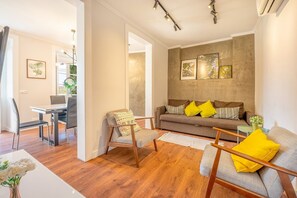 Ein modernes Wohnzimmer mit einer Couch, Sesseln und einem Essbereich.