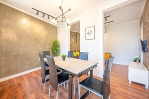 Un espace repas comprenant une table, des chaises et un lustre.
