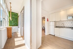 Une cuisine moderne avec des meubles blancs, un four à micro-ondes encastré et un plancher en bois.