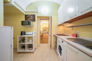 A compact kitchen with a microwave, coffee maker, and a washing machine. - GuestReady - Cosy studio near Santa Justa Lift (Lisbon)