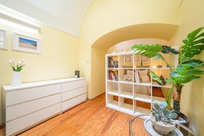 A room with a white console desk, a bookshelf, and a potted plant. - GuestReady - Cosy studio near Santa Justa Lift (Lisbon)