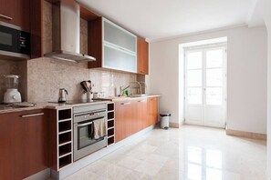 A modern kitchen with a built-in oven, microwave, and a large window. - GuestReady - Stunning duplex near Santa Justa Lift (Lisbon)