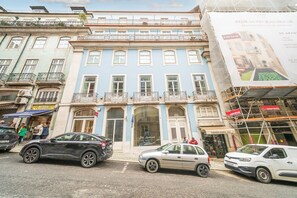 A multi-story building with a blue facade, a ground-floor shop, and a visible entrance. - GuestReady - Chic apt near Lisbon Cathedral (Lisbon)
