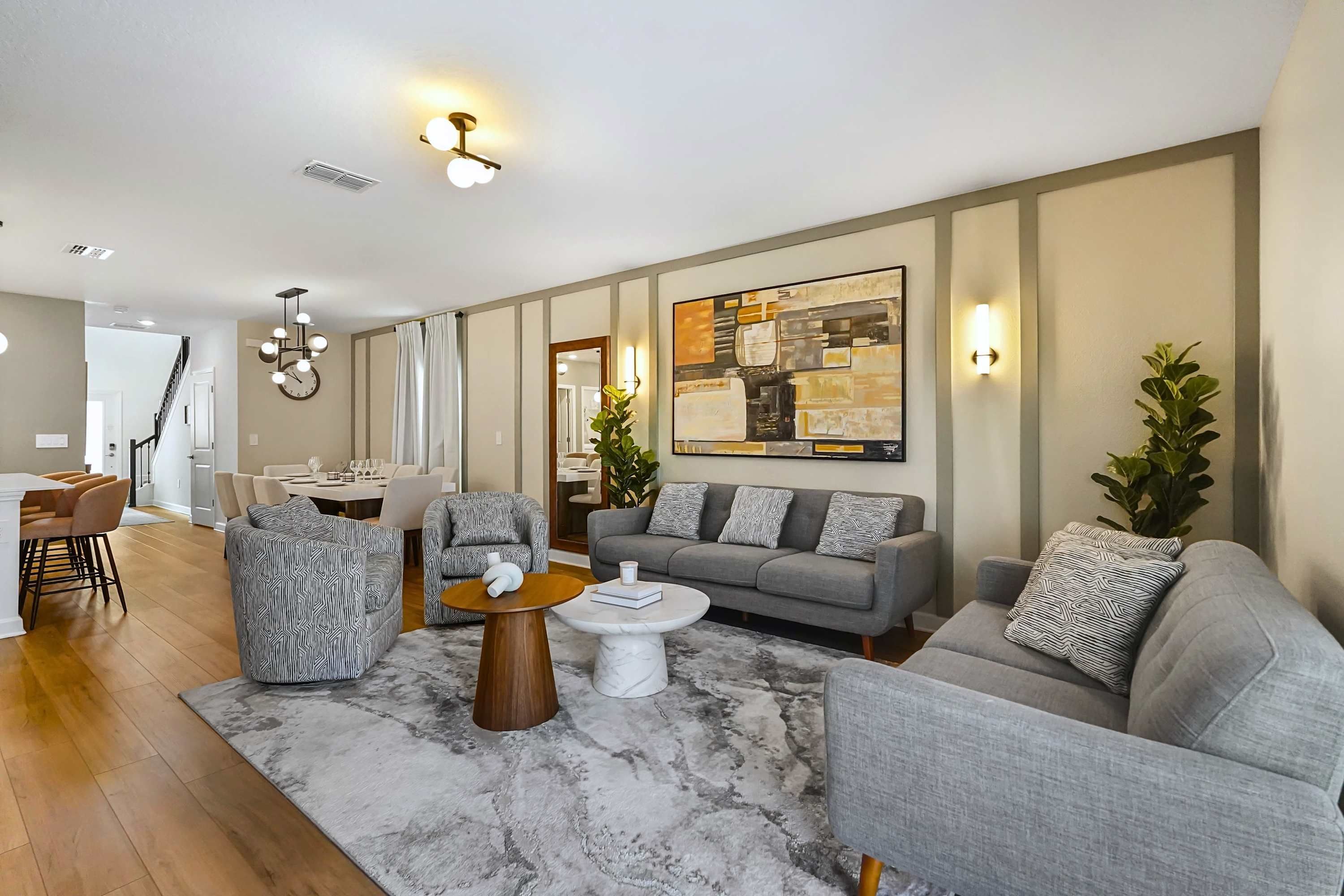 Una sala de estar moderna con un sofá, sillones, una mesa de centro y un comedor.