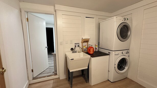 A compact laundry room with a washing machine, a dryer, and a small sink area.