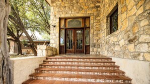 Un edificio de piedra con puerta de madera y una escalera que conduce a la entrada.