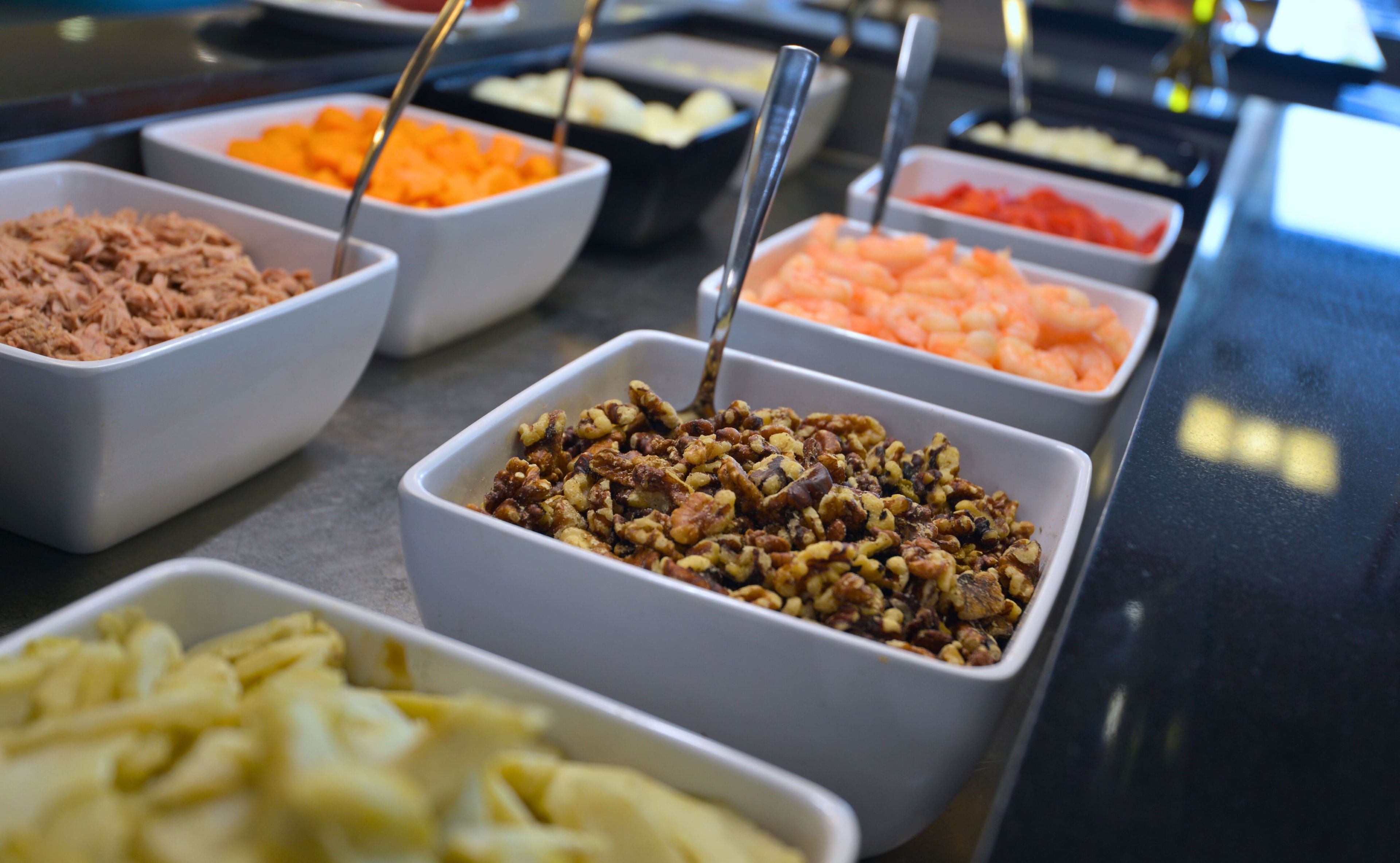 A buffet with various food options including nuts, fruits, and other dishes.