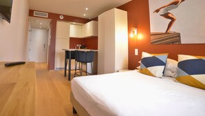 Una camera d'albergo con un letto, una scrivania e angolo cottura.