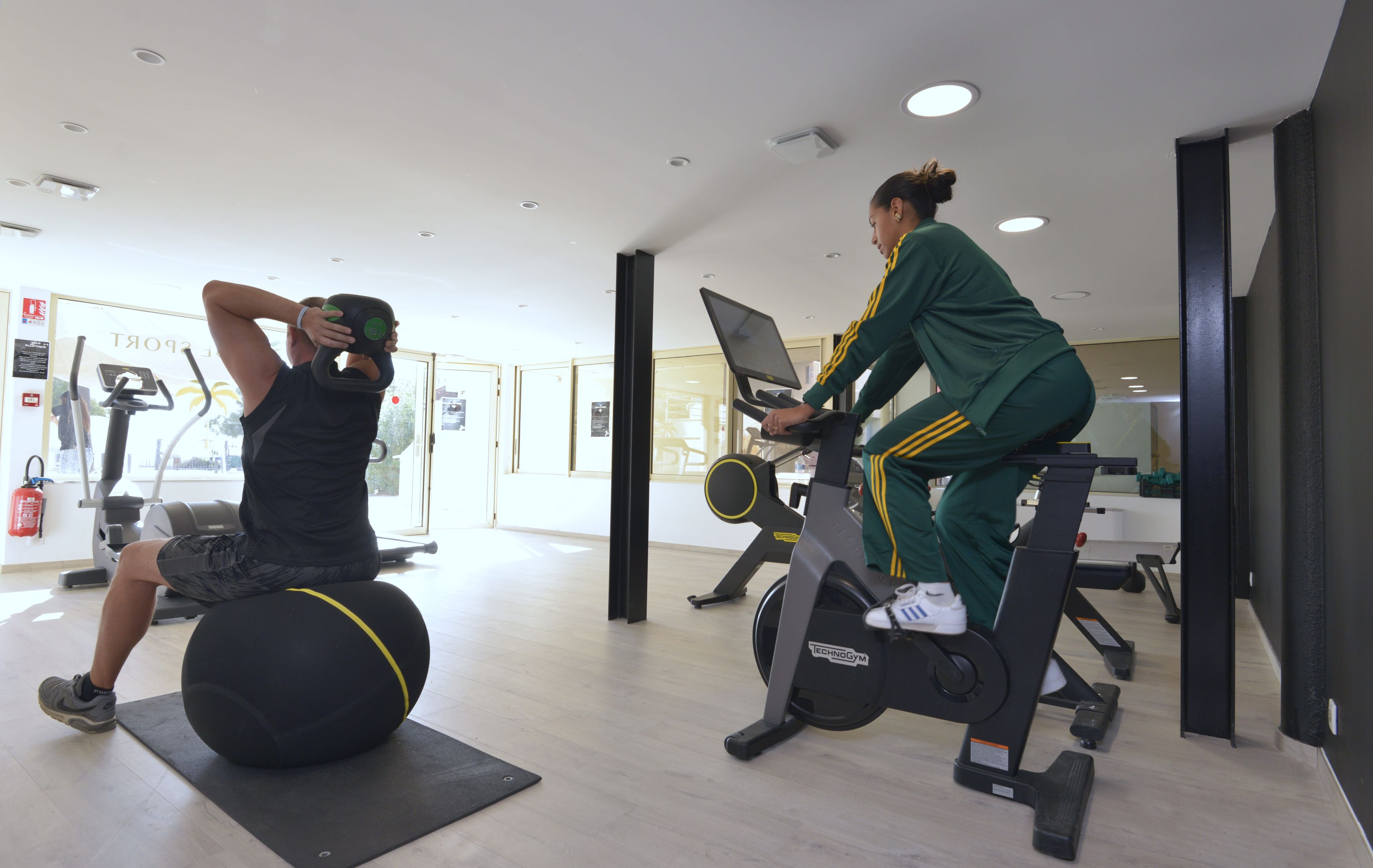 A gym with exercise equipment, including a stationary bike and a ball.