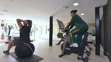 A gym with exercise equipment, including a stationary bike and a ball.