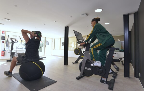 A gym with exercise equipment, including a stationary bike and a ball.