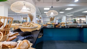 A modern breakfast buffet with wicker baskets and a variety of breads.