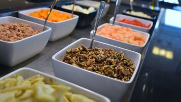 Un buffet proposant une variété de plats, notamment des fruits secs, des fruits frais et d’autres mets.