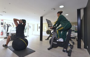 A gym with exercise equipment, including a stationary bike and a ball.