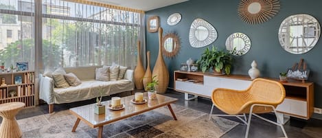 En moderne stue med sofa, sofabord og dekorative spejle på væggen.
