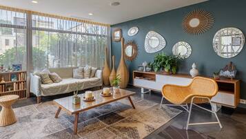 Un salon moderne avec un canapé, une table basse et des miroirs décoratifs accrochés au mur.