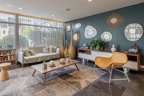 A modern living room with a sofa, coffee table, and decorative mirrors on the wall.