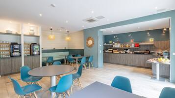Un restaurante moderno con zona de bar, asientos y un mostrador con productos alimenticios.