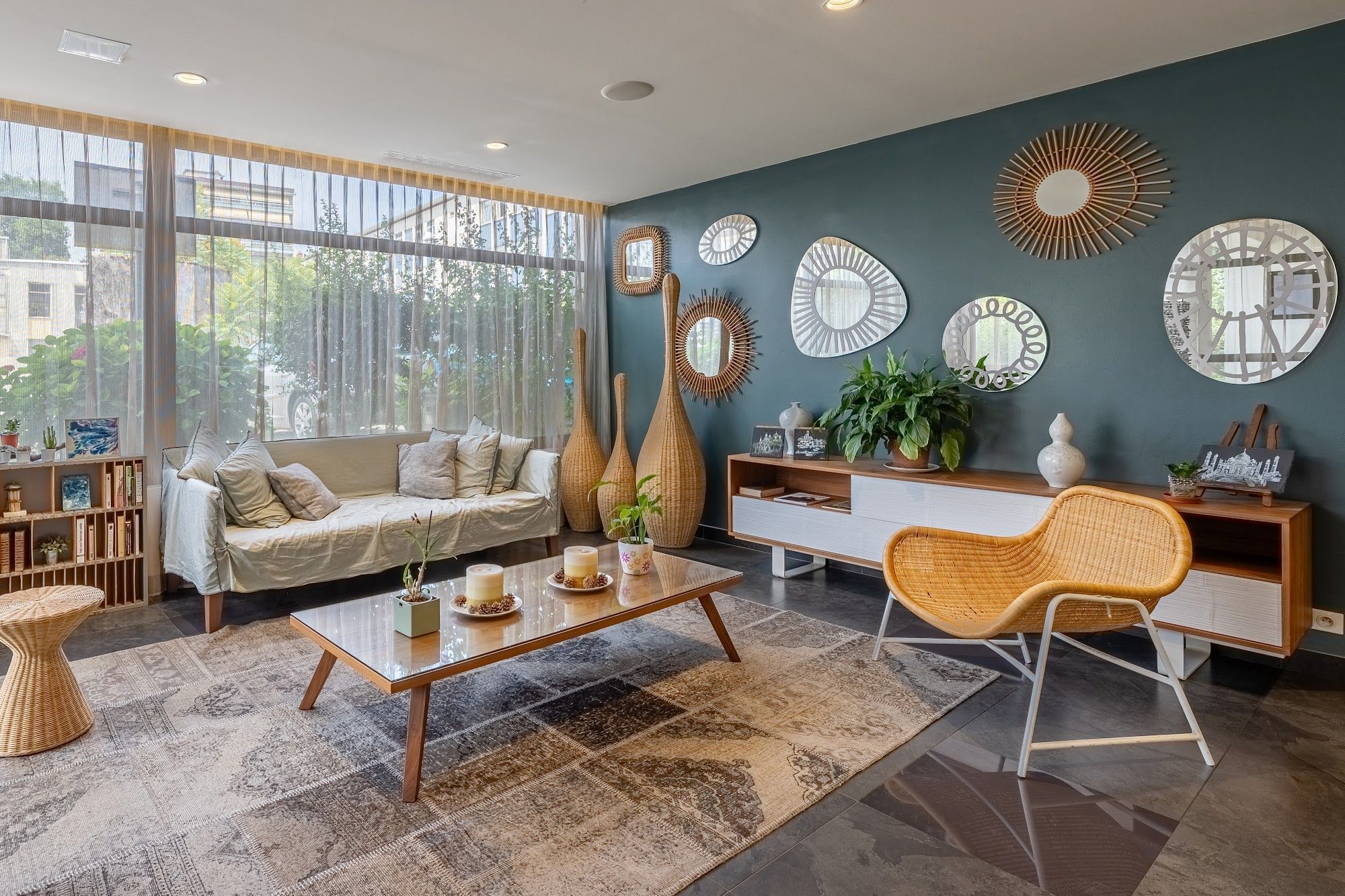 Uma sala de estar moderna com sofá, mesa de centro e espelhos decorativos na parede.
