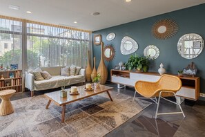 A modern living room with a sofa, coffee table, and decorative mirrors on the wall.
