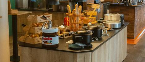 Una cocina con isla central, diversos electrodomésticos y un frasco de Nutella.