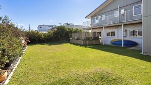 Una propiedad residencial con patio trasero cercado, un porche cubierto y un muelle para barcos.