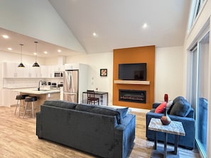 A modern living room with a sofa, a coffee table, and a fireplace.