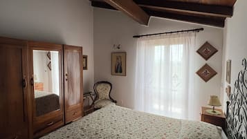 Una camera da letto con un letto grande, un'armadio di legno e una sedia.