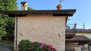 Un bâtiment en pierre doté d’un petit balcon et d’une entrée fermée par un portail.