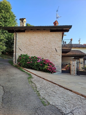 A stone building with a small balcony and a gated entrance.