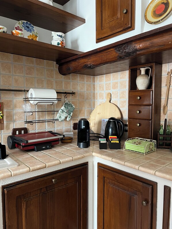 A kitchen with a coffee maker, a toaster, and a knife block on the counter.