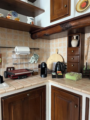 A kitchen with a coffee maker, a toaster, and a knife block on the counter.