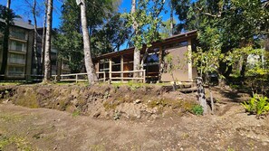 Un edificio con una terraza de madera y un sendero de tierra que lleva a él.