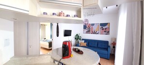 A modern living space with a sofa, a coffee table, and a TV mounted on the wall. - JK & Faria Lima | Functional Apartment in Itaim Bibi (São Paulo)