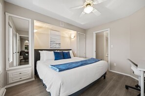 A bedroom with a bed, a ceiling fan, and a large mirror. - Riviera | Balcony w/ Mountain Views | Pets | Golf (Fairmont Hot Springs)