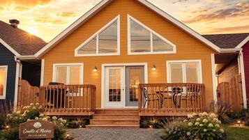 A two-story house with a wooden deck, a front door, and a sign that reads 'Couette et Marées STE-LUCE-SUR-MER.'