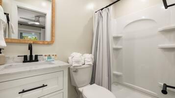 A modern bathroom with a toilet, sink, and shower.