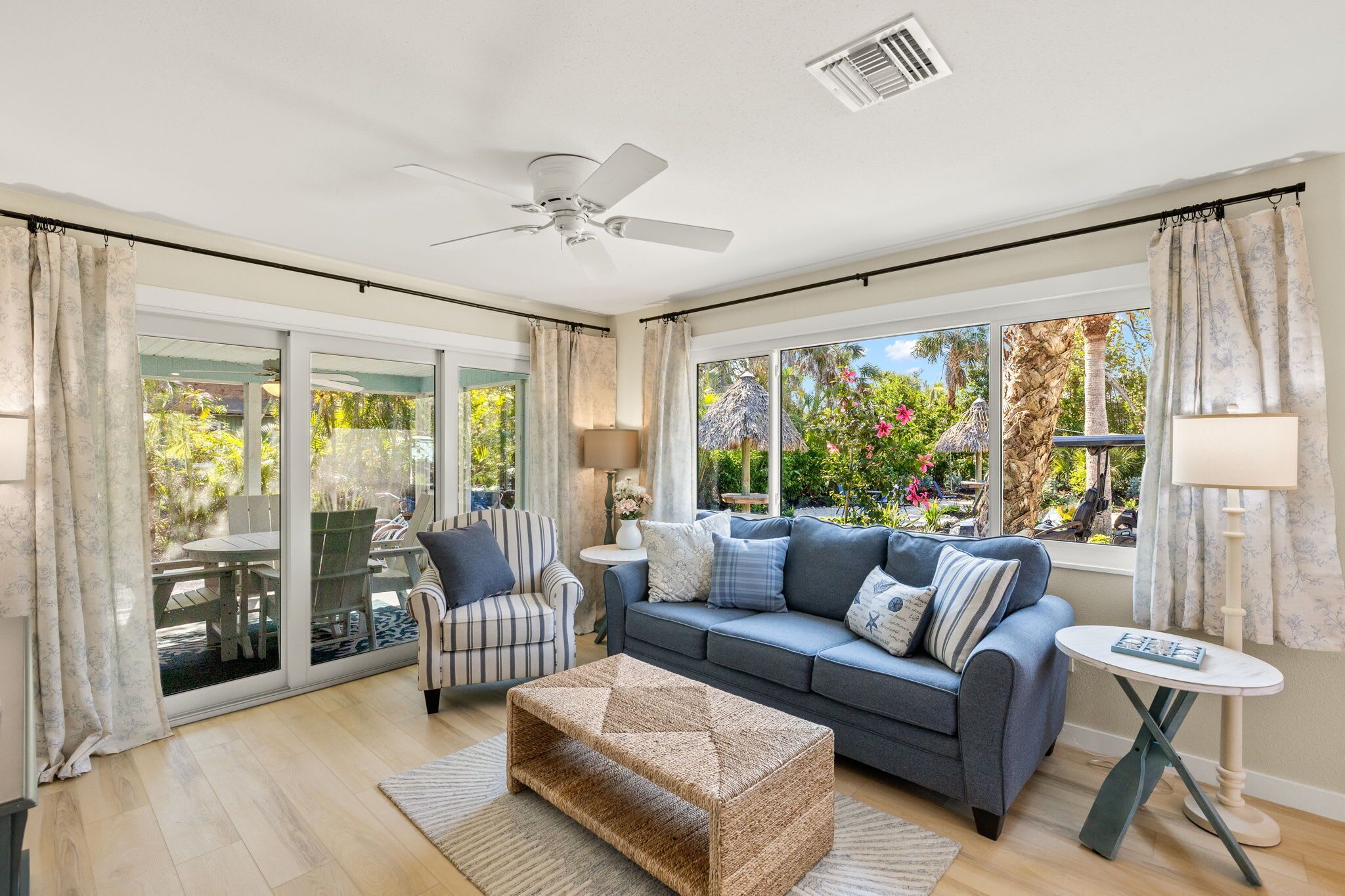 A spacious living room with a sofa, armchair, and a small table.