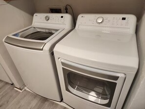 Ein Waschbereich mit zwei weißen Waschmaschinen und einem Trockner.