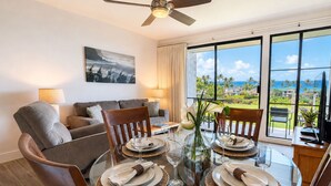 A dining area with a glass table, chairs, and plates set for a meal. - Villa, Oceanfront, 1-bedroom (Napili-Honokowai)
