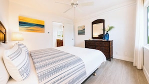 A bedroom with a bed, a dresser, a mirror, and a ceiling fan. - Villa, Oceanfront, 1-bedroom (Napili-Honokowai)