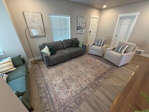 A living room with a grey sofa, a patterned rug, and two armchairs. - Charming 3BR/1BA Burley home w/ full yard, near park, shops & Snake River (Burley)