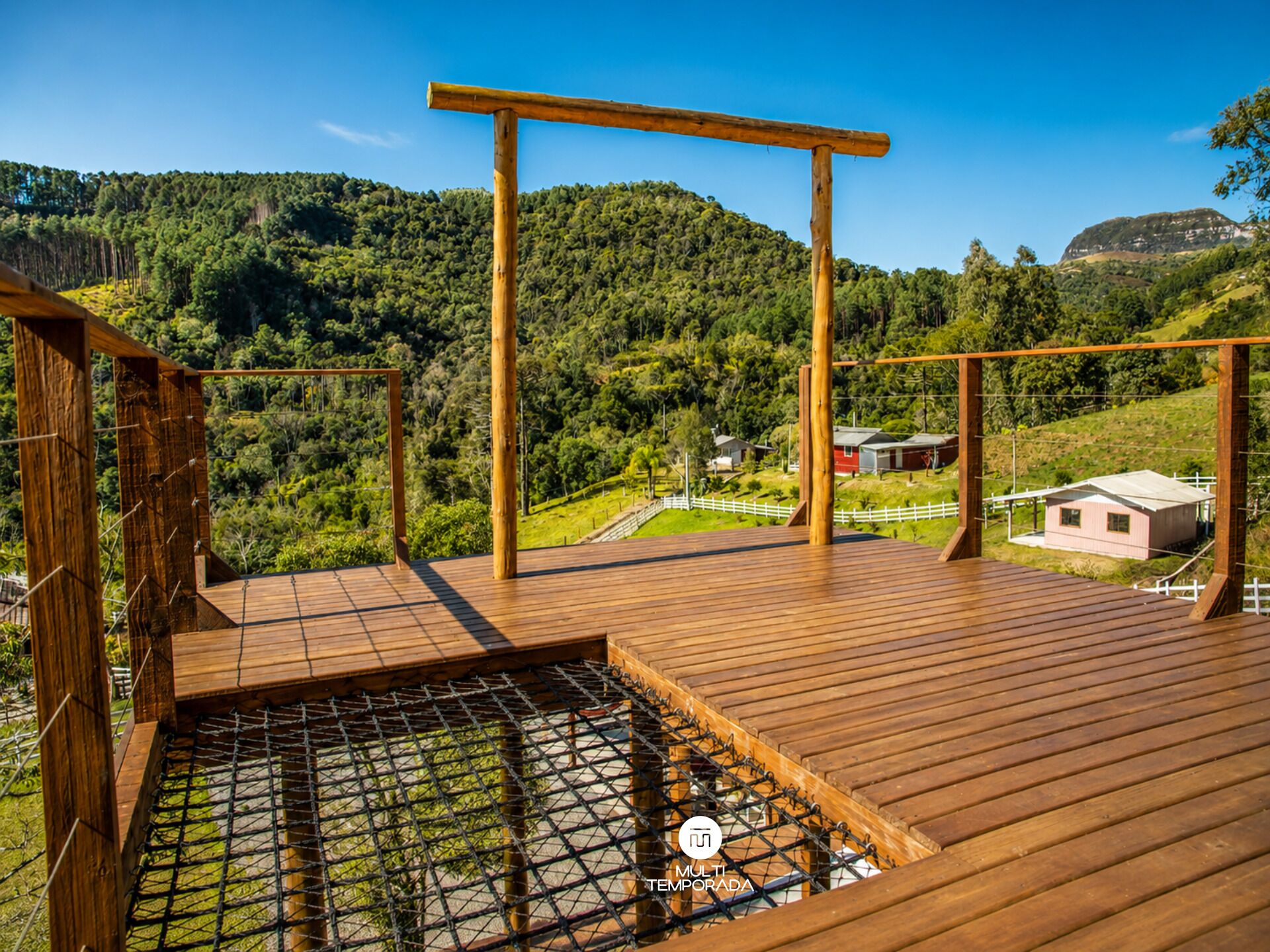 Una terraza de madera con vistas a un paisaje montañoso.